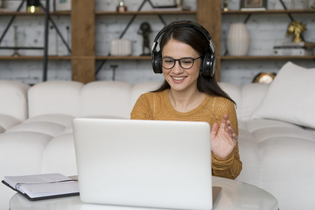 Woman with headphones following online Dutch lessons from home.