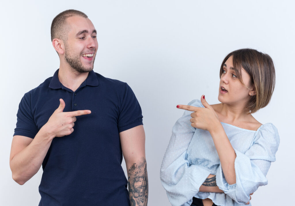 Two people pointing at each other