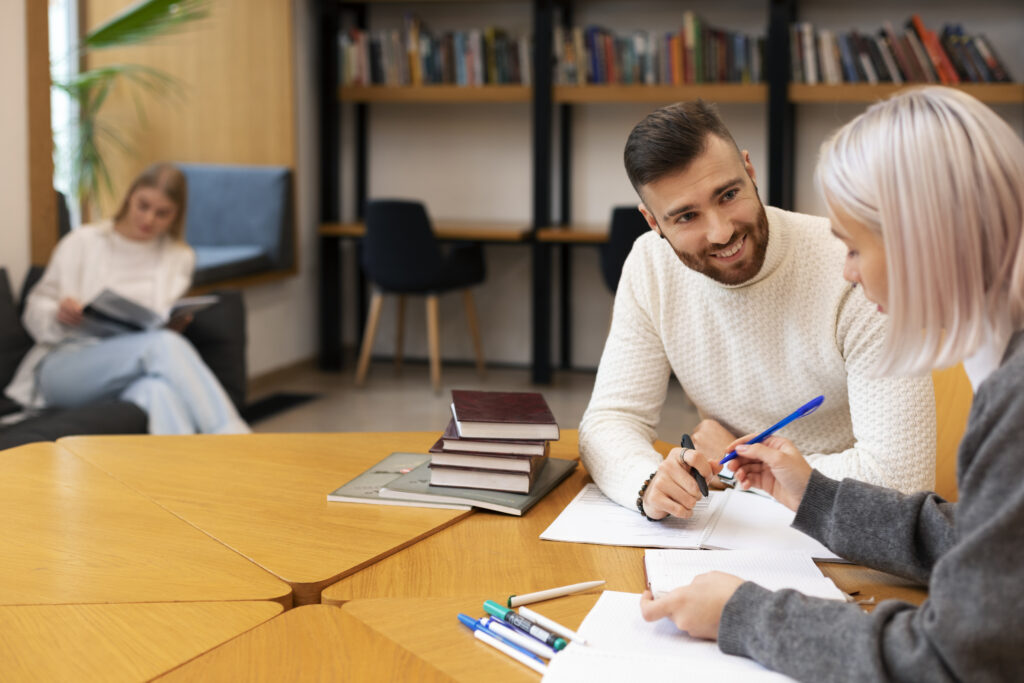 Tutor and student in a library, during one of their Dutch lessons in Amsterdam.