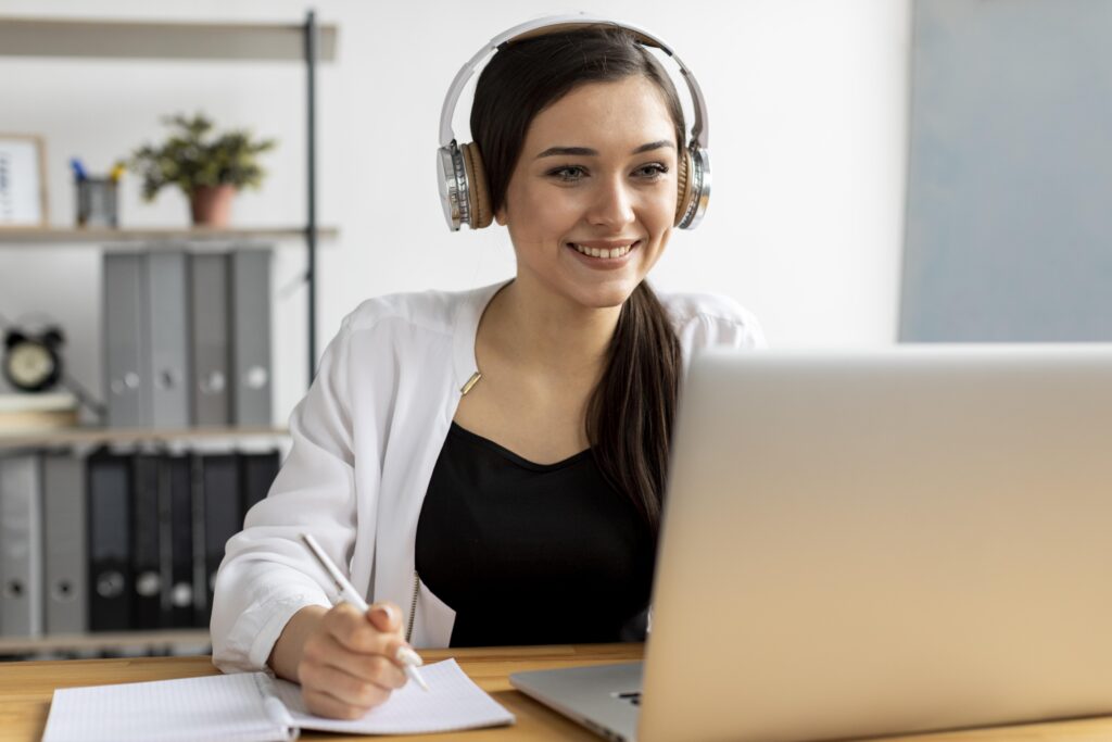 Smiling woman with headphones following her Dutch B1 exam training.