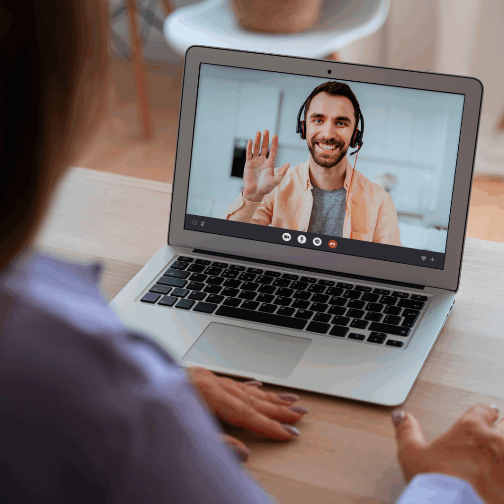 Online Dutch tutor with headphones waving to his student at the start of the test lesson.