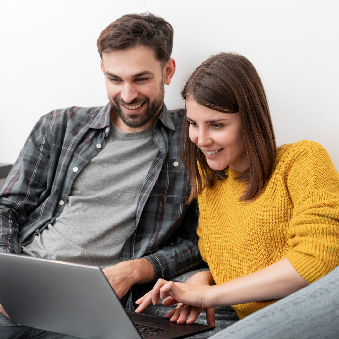 Man and woman on the couch behind their laptop, following Dutch lessons for couples.