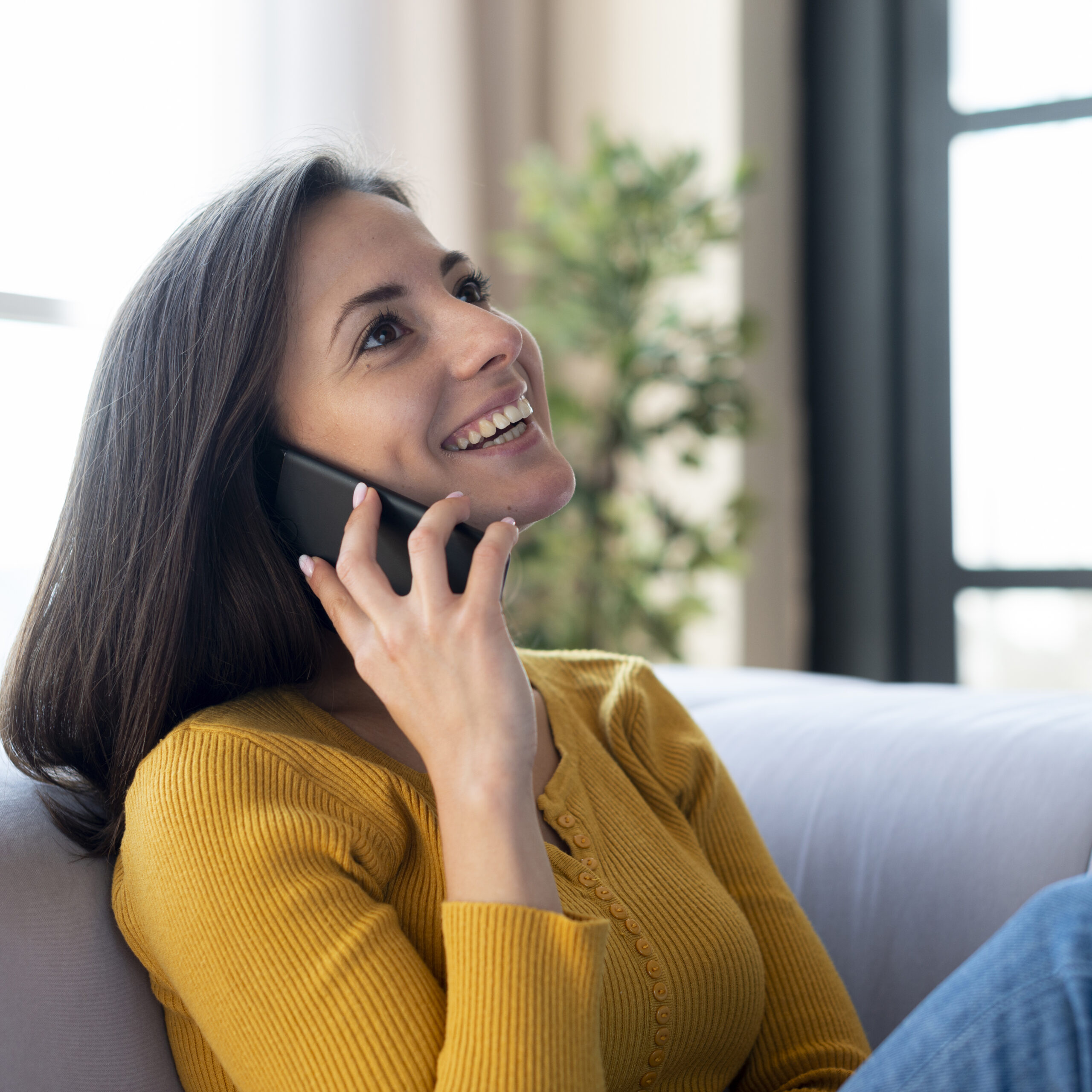 Young woman looking for Dutch lessons, talking on the phone to learn more about the options at the language school.