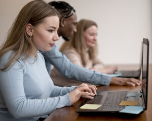 Students working on their laptop in preparation for the Dutch civic integration exam.