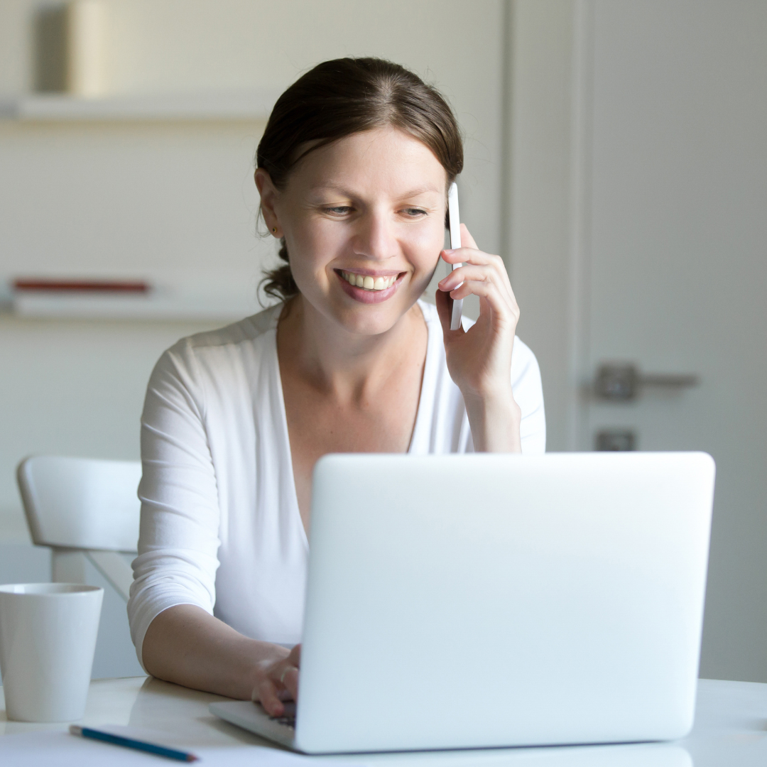 Woman dressed in white having a phone conversation about her Dutch inburgering exam.