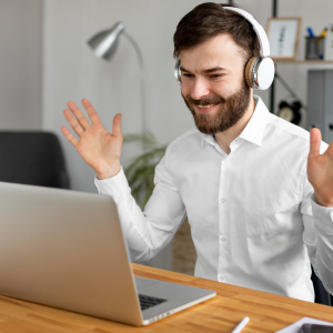Man wearing headphones, following online 1:1 Dutch conversation lessons from his laptop.