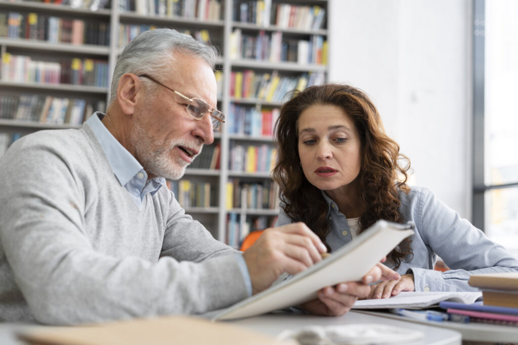 A Dutch tutor explaining grammar to a student who is listening attentively.