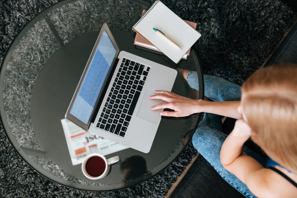A woman doing preliminary exam prep for Dutch on her laptop while enjoying a cup of coffee.