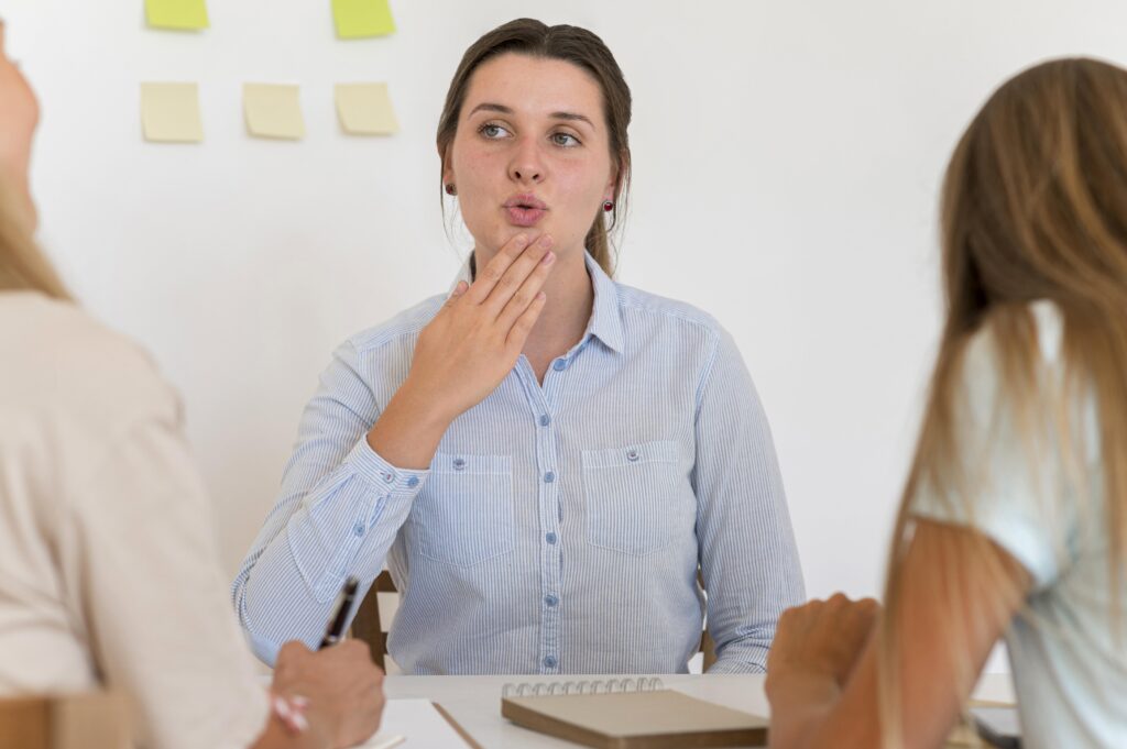 A Dutch teacher demonstrating the correct mouth shape to students to help them pronounce words correctly.