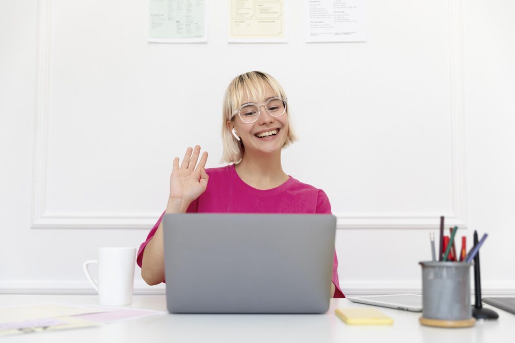 Dutch student with learning difficulties greeting her tutor at the start of their online lesson.